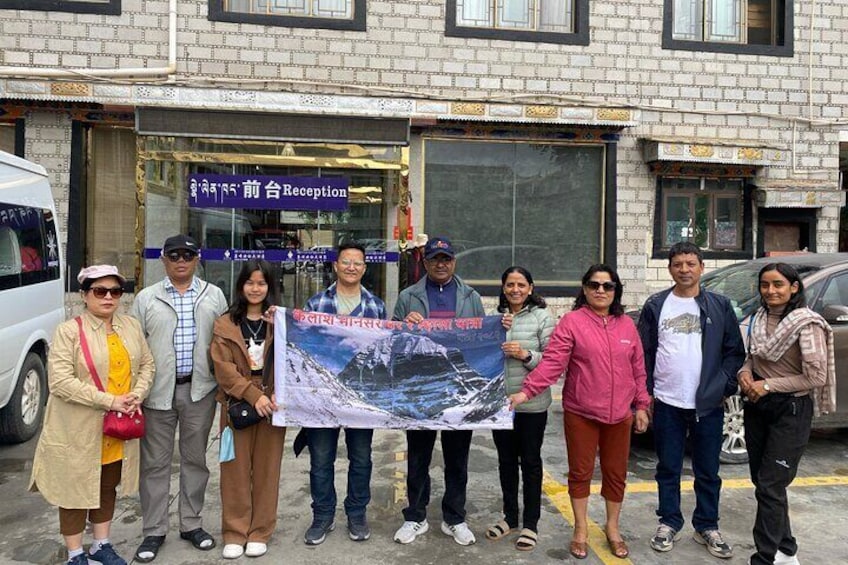 A group of people holding a banner in front of a building with a reception sign. 1