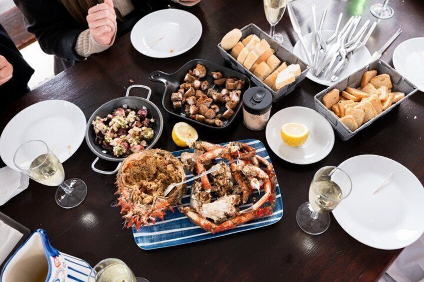 Ett bord med fisk- och skaldjursrätter, bröd och vinglas. 1