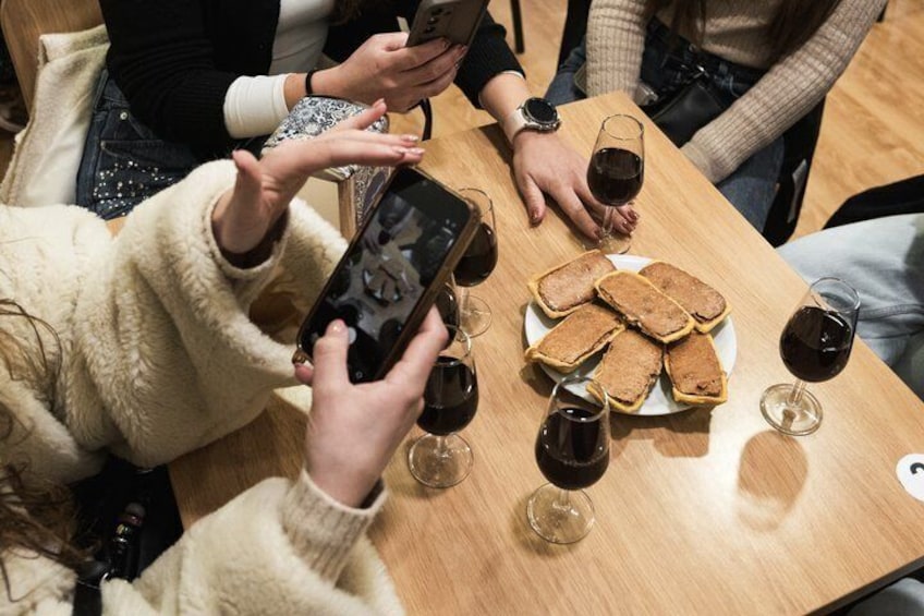 Personer sitter vid ett bord med bröd och vinglas. 2