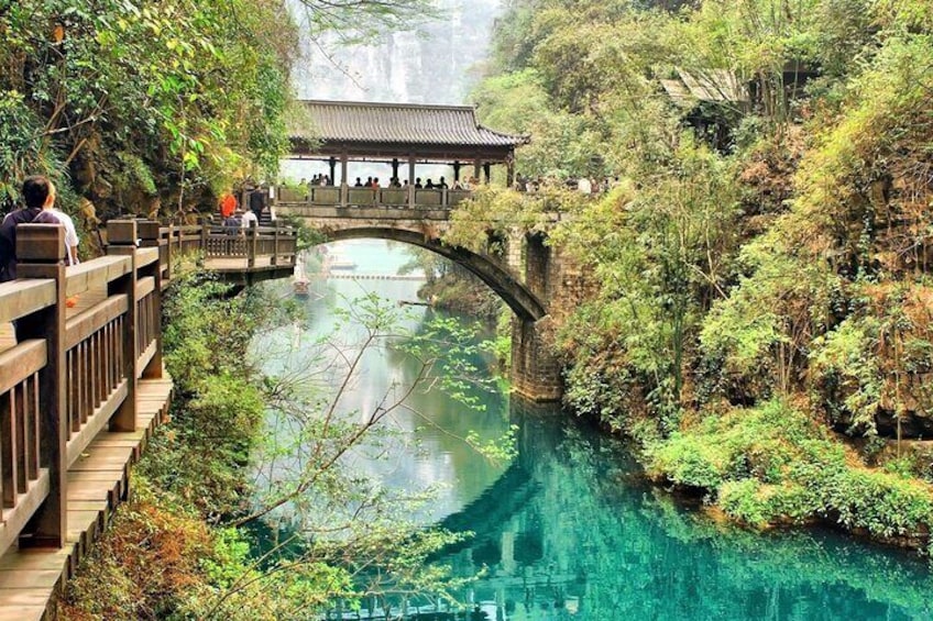 A serene river with a wooden bridge and a traditional pavilion. 5
