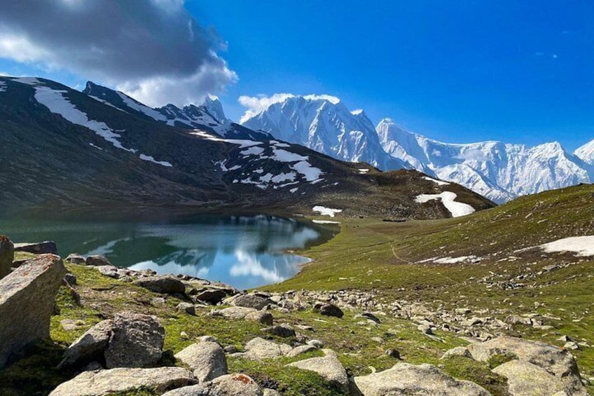 Paisaje montañoso con un lago, picos nevados y terreno rocoso. 4