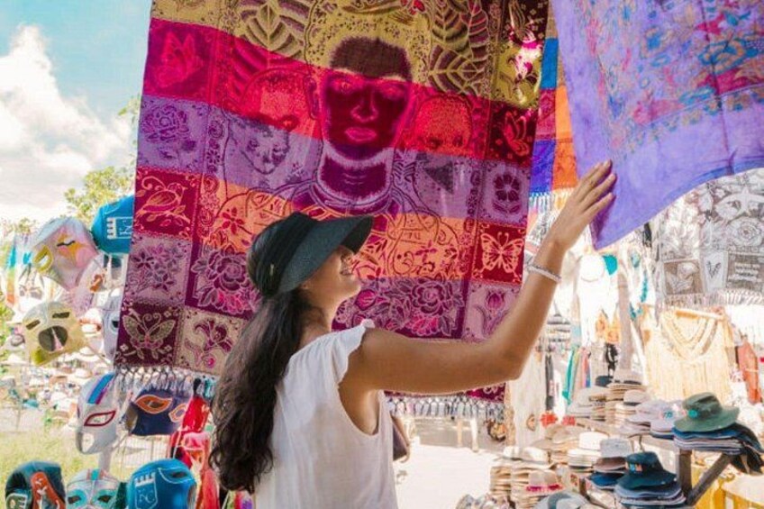 A person holding a colorful tapestry with intricate patterns. 2