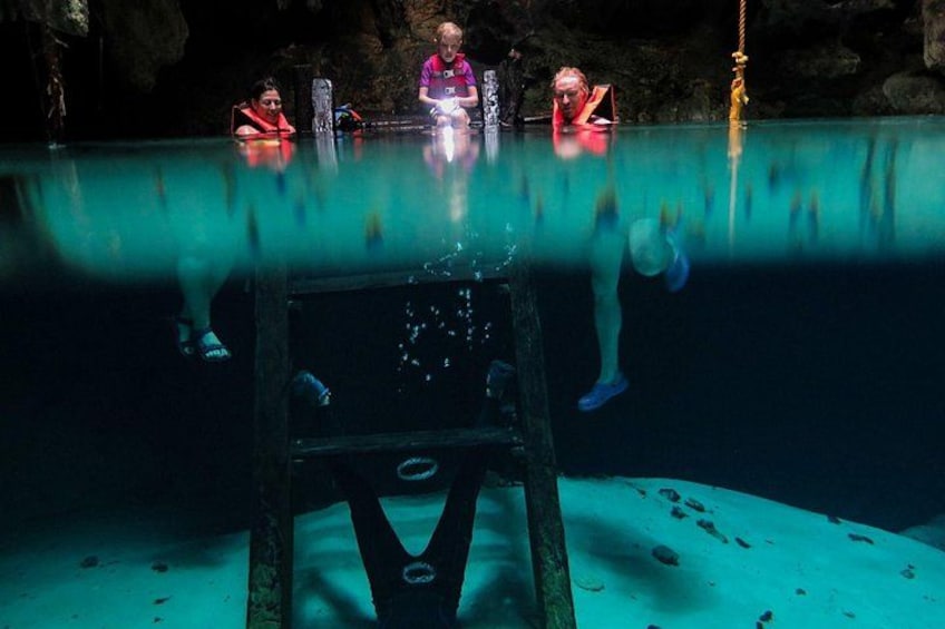 An underwater scene with a person in a red life jacket and another in a purple life jacket. 3