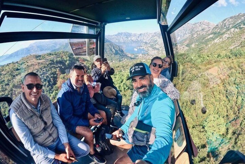 A group of people on a cable car with a mountainous landscape in the background. 2