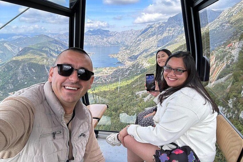 A person taking a selfie with a scenic mountain view in the background. 3