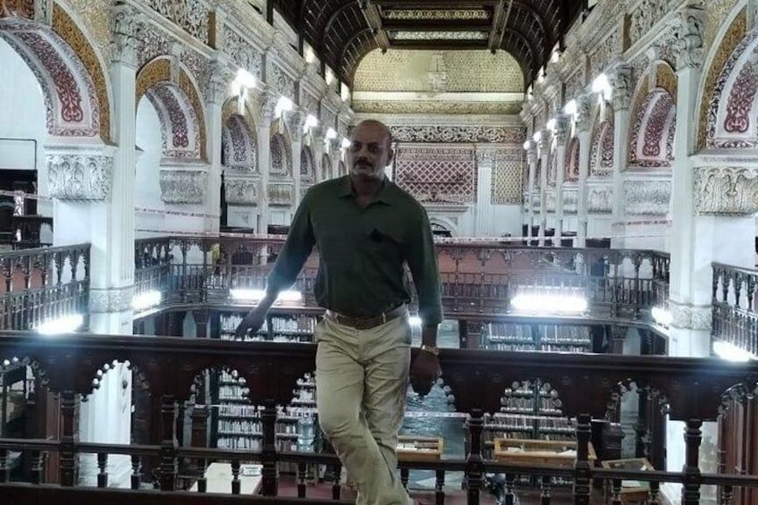 A man walking inside a grand, ornately decorated building with high ceilings and intricate architectural details. 3