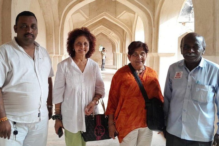 A group of people standing in a corridor with arched ceilings and columns. 4