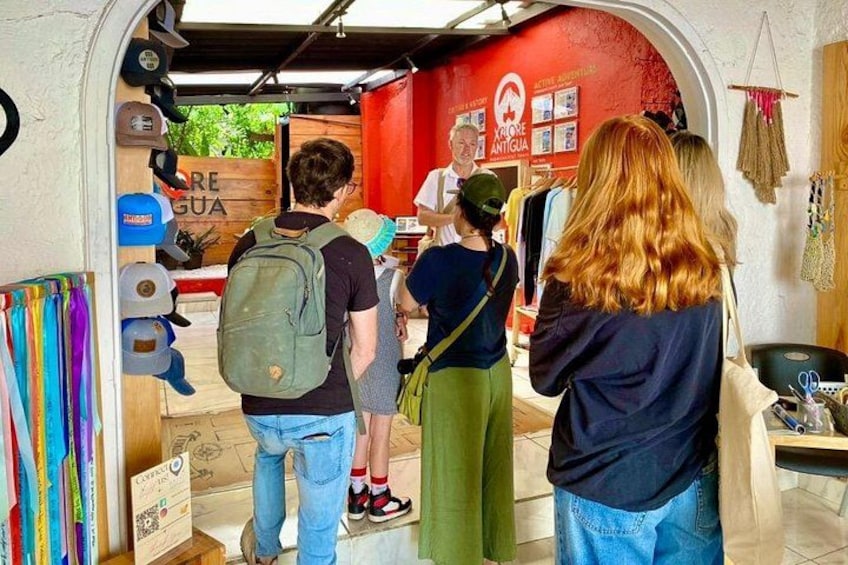 A group of people entering a store with a red wall and a wooden door. 3