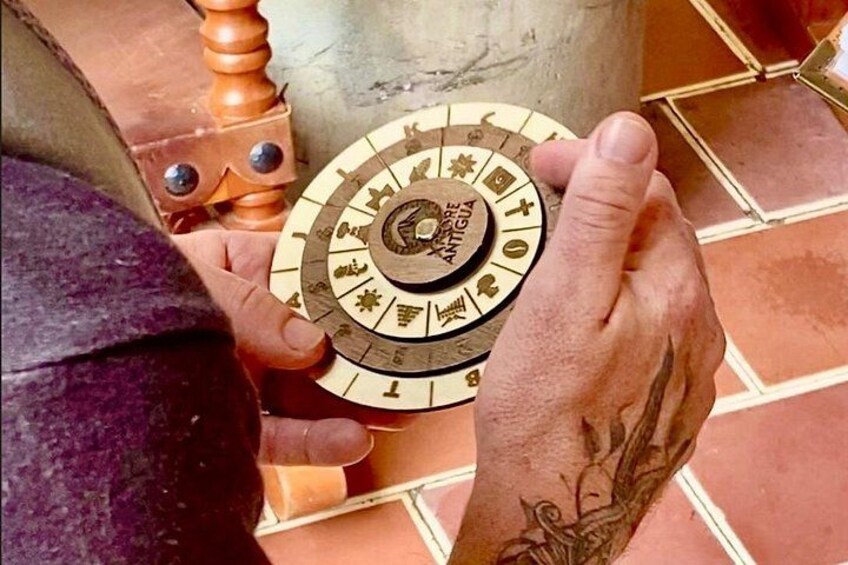 A person holding a circular object with inscriptions and symbols, possibly a historical artifact or a decorative item. 4