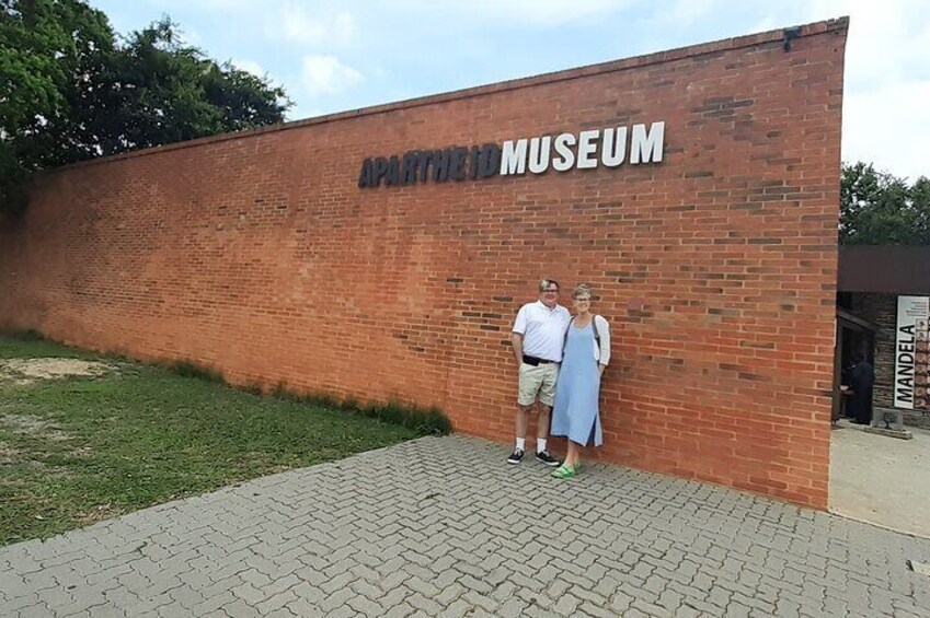 A brick wall with the text "APARTMENT MUSEUM" and a paved walkway. 5