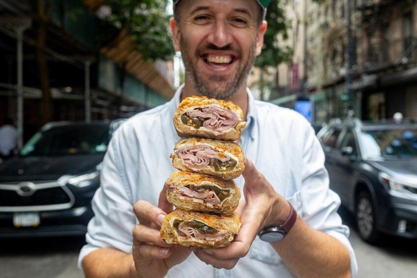 Una persona sosteniendo un sándwich con varias capas. 1