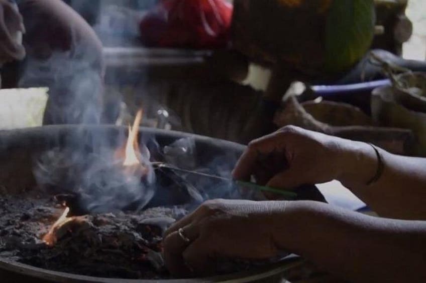 Hands cooking over an open flame with visible smoke. 3