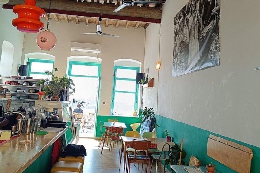 A cozy cafe interior with wooden furniture, a bar counter, and green walls. 4