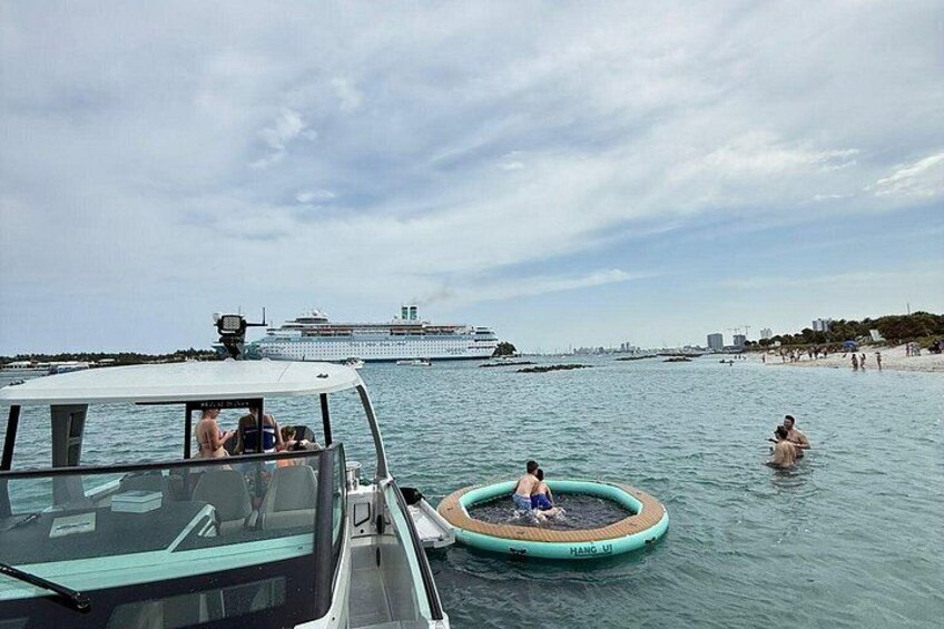 Et krydstogtskib, en lille oppustelig pool og en strand med folk i vandet. 5