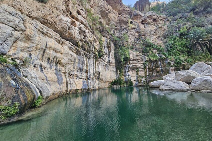 Een canyon met helder water, rotsachtige kliffen en grote rotsblokken. 2