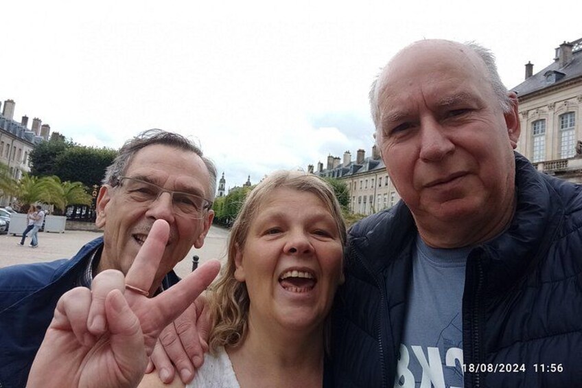 Tres personas posando con un gesto de paz frente a un edificio de arquitectura clásica. 2