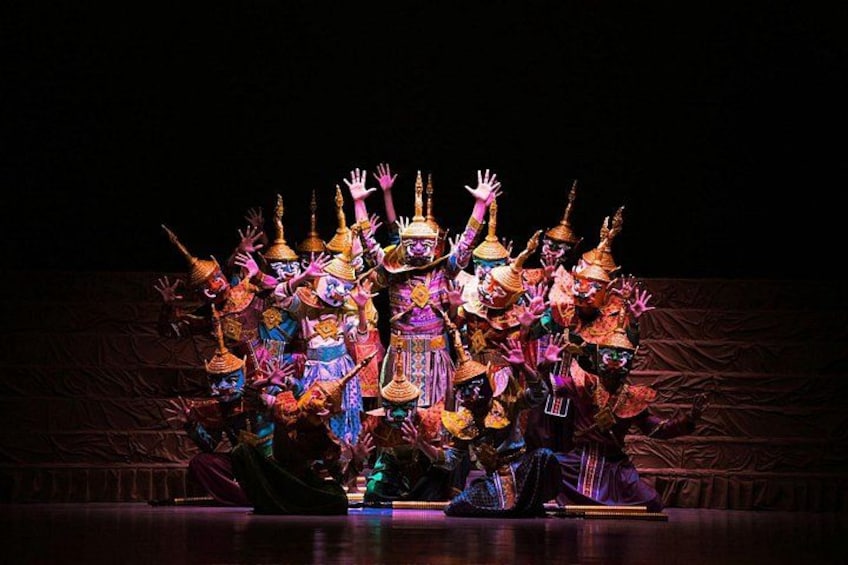 Un grupo de artistas en vestuario colorido y elaborados tocados en un escenario. 3