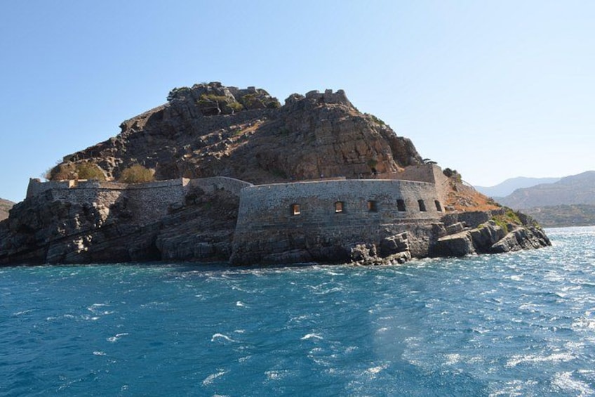 A rocky island with a fortified structure and clear blue waters. 2