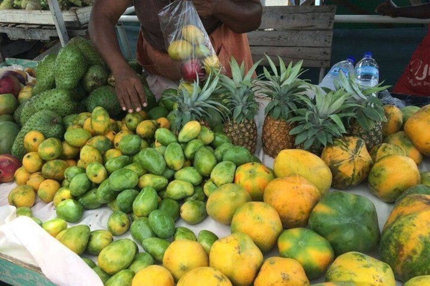 Eine Auswahl an Früchten, darunter Mangos, Ananas und Papayas, präsentiert auf einem Markt. 3