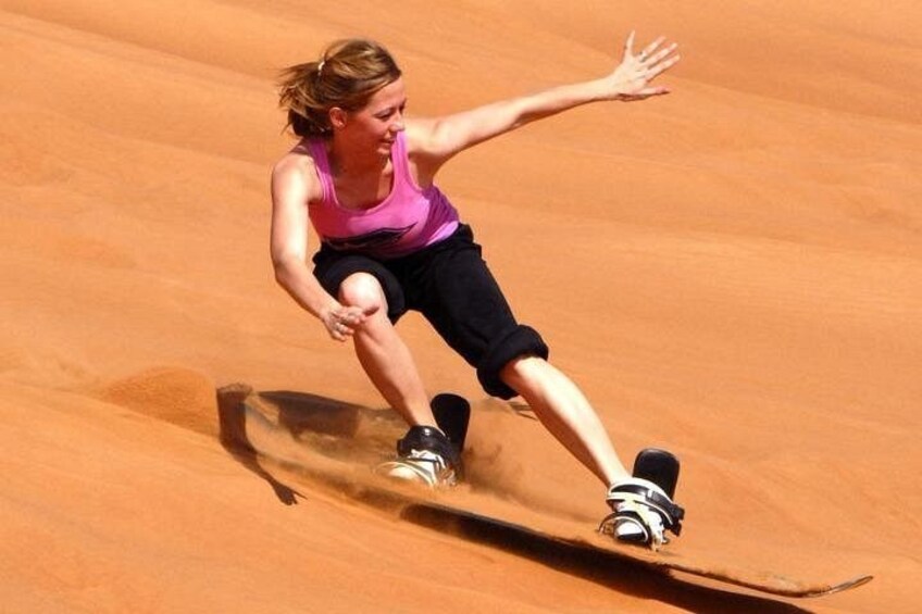 Una persona practicando snowboard en una ladera arenosa. 5