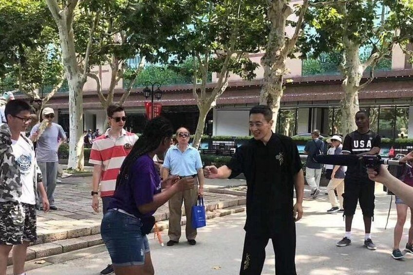 A person in a black shirt with a USA flag patch, standing on a sidewalk. 4