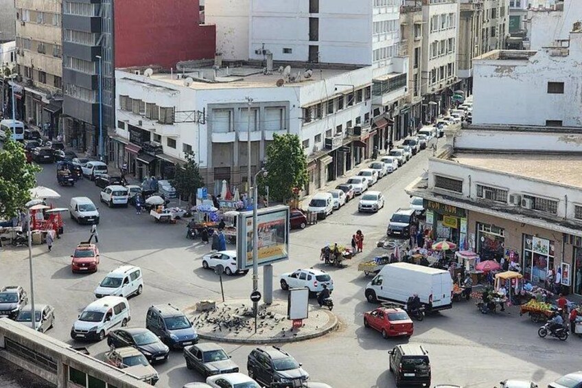 A busy urban street with cars, motorcycles, and pedestrians. 1