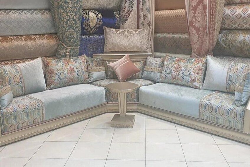 A corner sofa set with patterned cushions and a small round table. 5