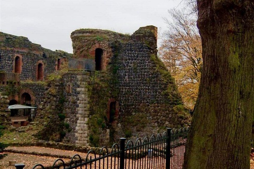 A historic stone structure with arches and a fenced area. 3