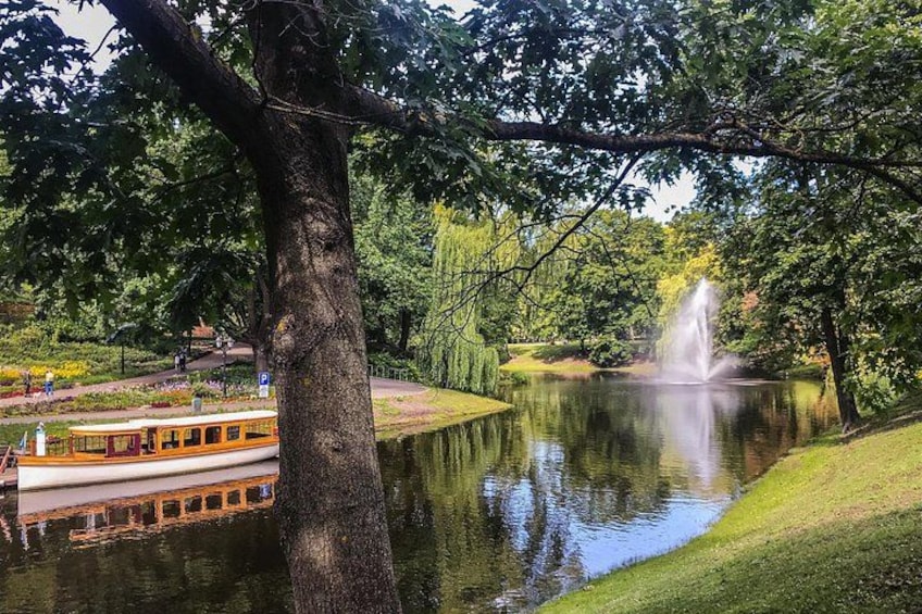 A river with a boat, a fountain, and a tree. 5