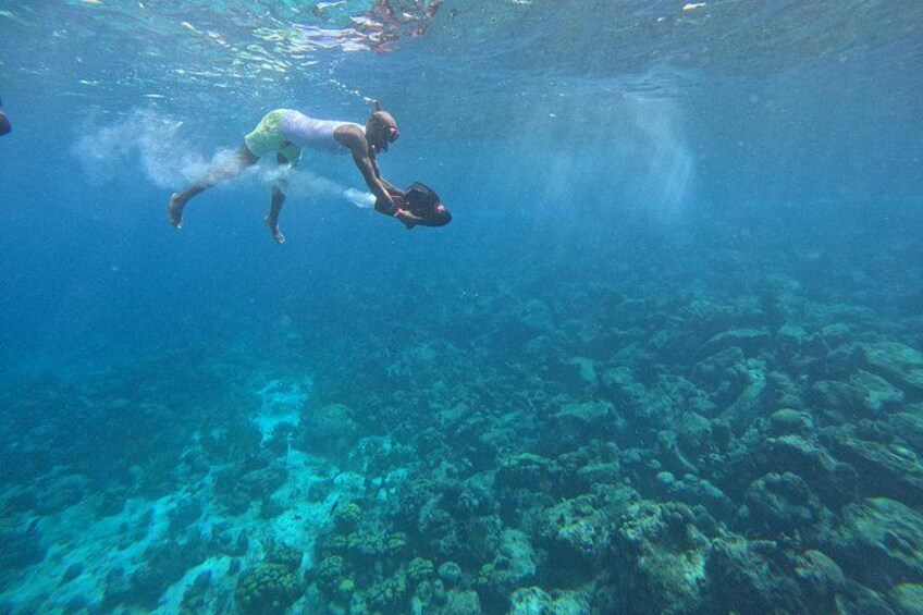 A person swimming underwater with a snorkel. 4