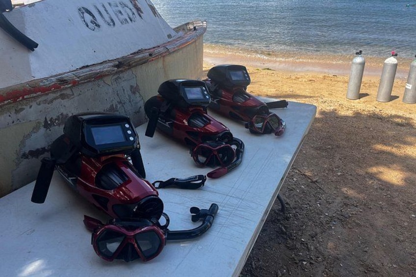 A boat with scuba gear and oxygen tanks on a sandy beach. 3
