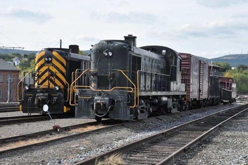 A train with a yellow and black stripe on the front, moving on a railway track. 2