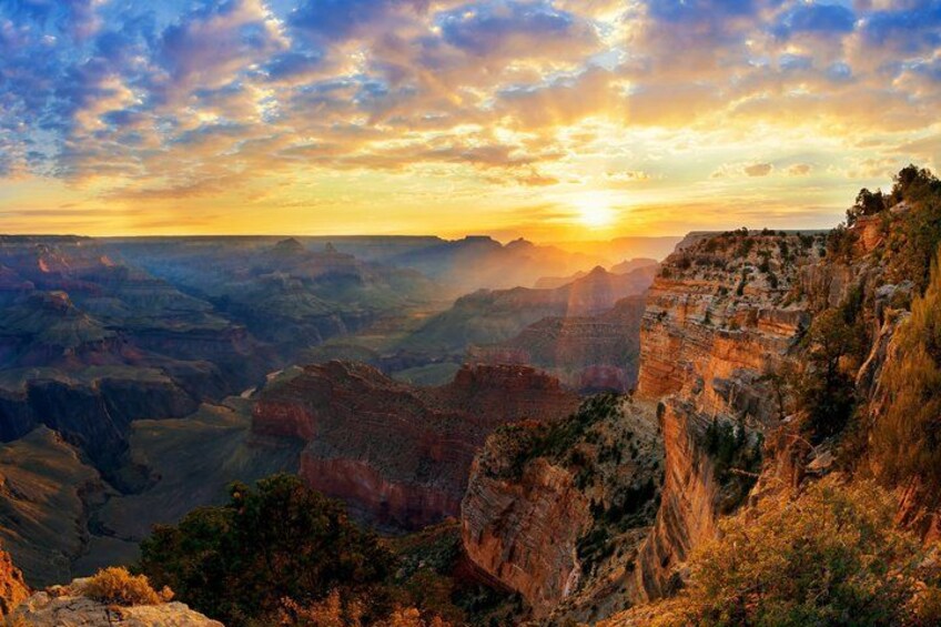 A canyon landscape with layered rock formations and a sunset. 2