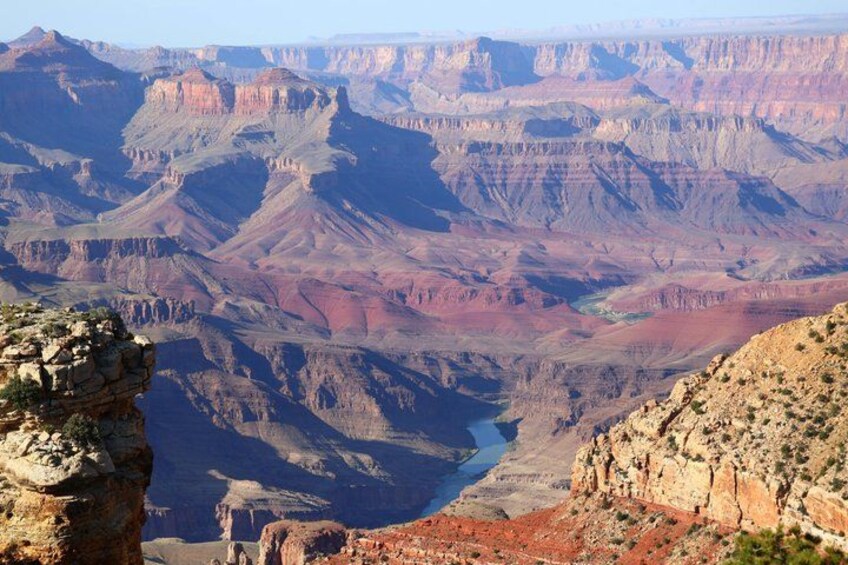 A canyon landscape with layered rock formations and a visible river. 3