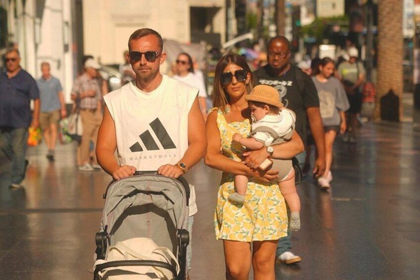 Travelers exploring Hollywood Boulevard with kids. 3