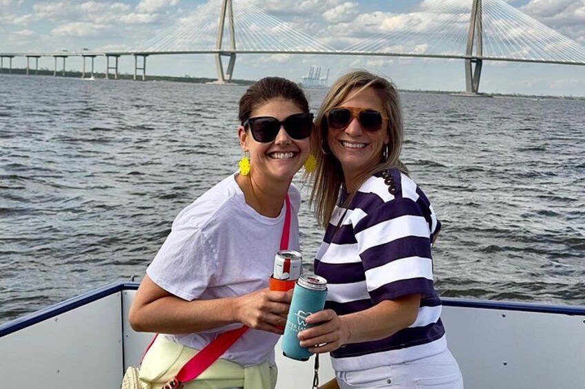 Two people on a boat with a bridge in the background. 2