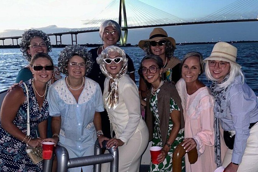 A group of people on a boat with a bridge in the background. 4