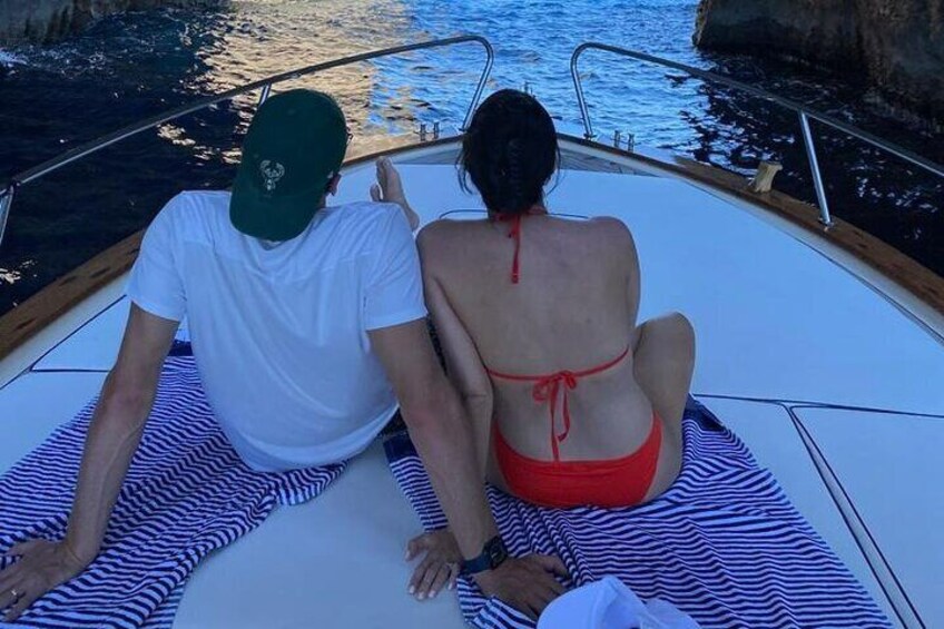Two people on a boat with a striped mat. 1