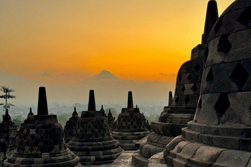 Ancient stone structures with a mountain in the background during sunset. 1