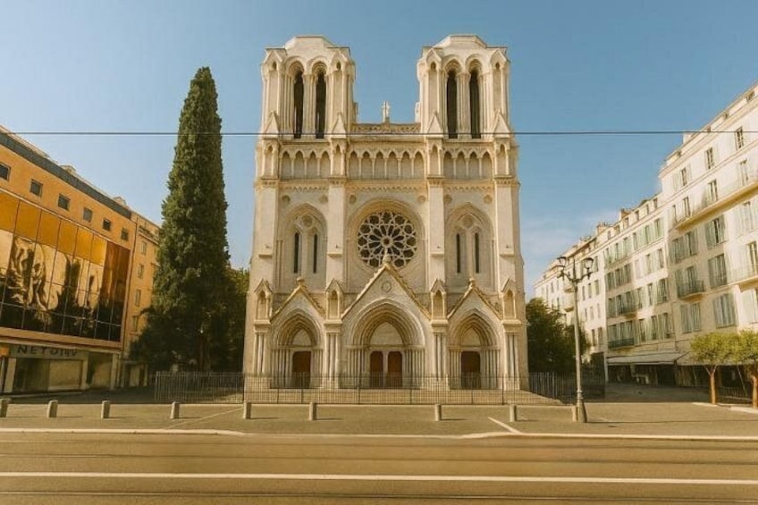 Una catedral con dos torres, un rosetón grande y una estatua en primer plano. 2