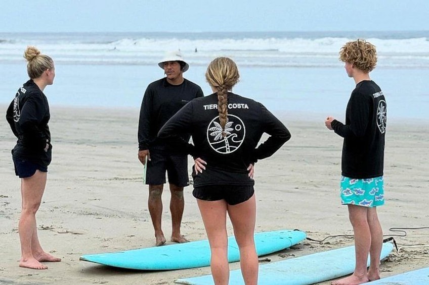 Un groupe de personnes sur une plage, avec des planches de surf. 1