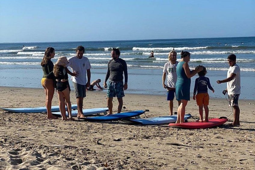 Un groupe de personnes sur une plage, avec des planches de surf. 5