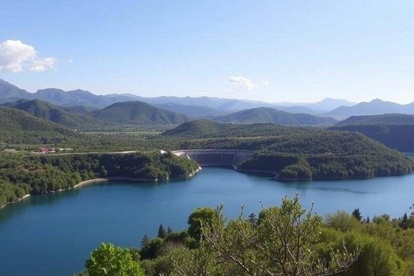 A lake surrounded by mountains, a bridge, and dense greenery. 5