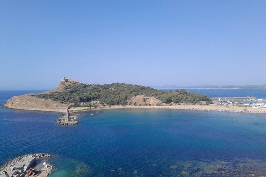 A coastal landscape with a prominent hill, a small island, and a clear blue sea. 3