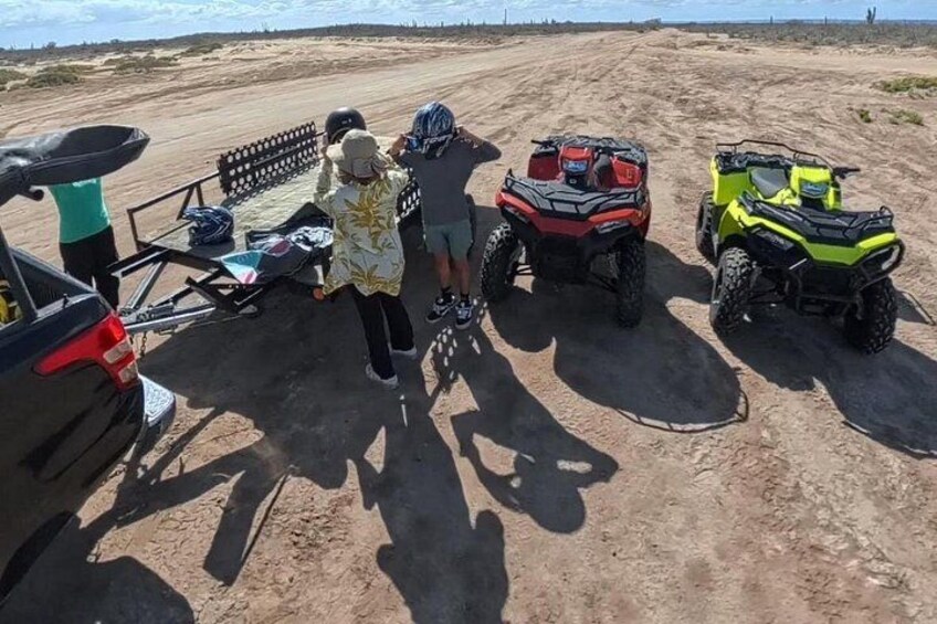 En sandstrand med ATV'er og en bil. 3