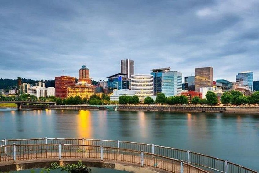 A city skyline with modern buildings, a river, and a bridge. 2
