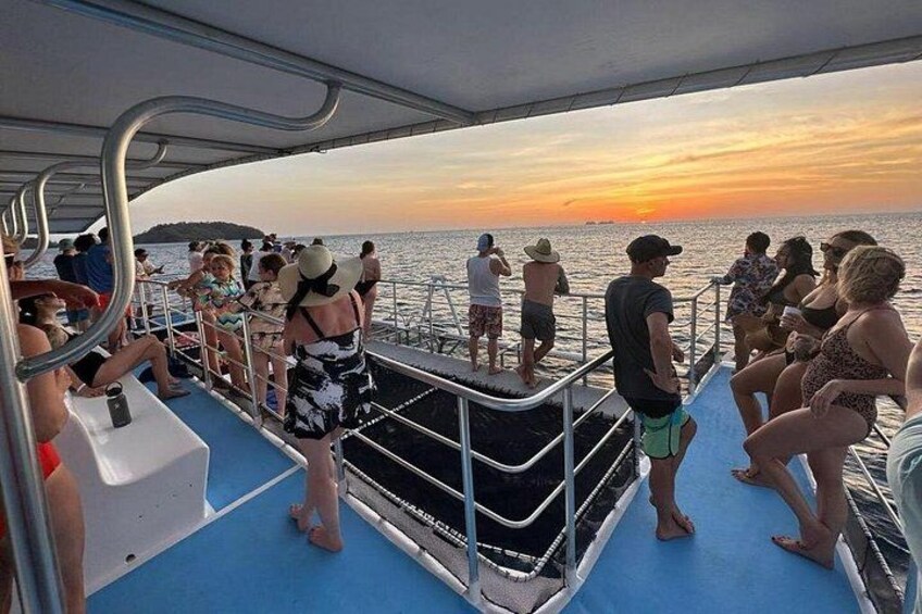 Vista al tramonto da una barca con persone in piedi sul ponte. 2