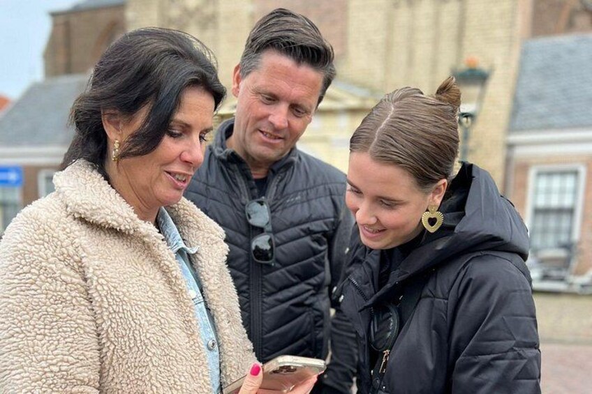 Tre persone in piedi all'aperto, una tiene in mano uno smartphone. 2