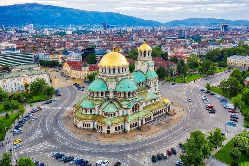A large cathedral with multiple domes, surrounded by a cityscape with roads and buildings. 2
