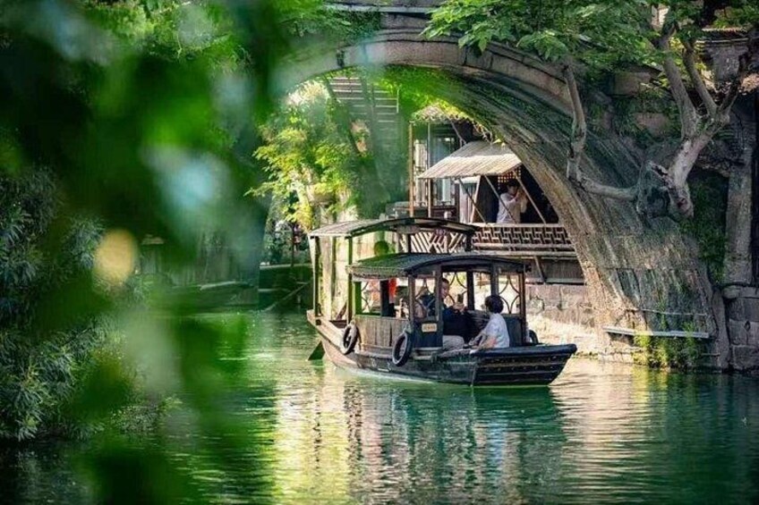 A boat with passengers on a river, passing under a stone bridge. 3